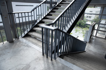 Empty concrete staircase with black steel handrail.