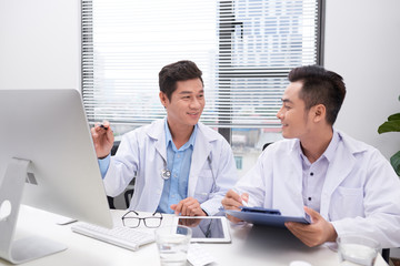 Fototapeta premium Hardworking doctors reviewing patient's file
