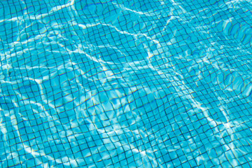 Hotel swimming pool with sunny reflections.Ripple Water in swimming pool with sun reflection. Blue swimming pool rippled water.swimming, pool, waves under sun light