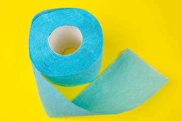 roll of blue  toilet paper on a yellow background