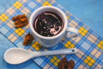 berry jam in a white cup on a blue background.