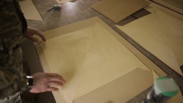Work with veneer, trimming and stitching the veneer with a special thread, facing material in woodworking, joinery workshop