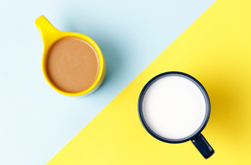 A cup of coffee and milk on a yellow and blue background, top view