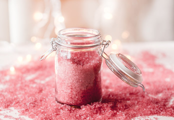 Pink sea salt in a jar on bokeh background