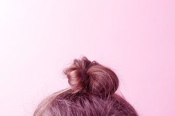 Modern Hairstyle bun on a pink background, copy space