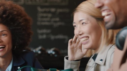 happy group of friends hanging out in coffee shop chatting sharing conversation enjoying socializing having fun in cafe