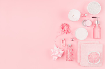 Different cosmetic products and accessories in pink and silver color on soft light pink background, copy space, top view.