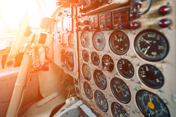 Dashboard of an old airplane. Many analog pointers, buttons and switches