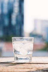 Glasses with ice cubes on wooden table