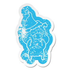 happy cartoon distressed sticker of a pig wearing santa hat