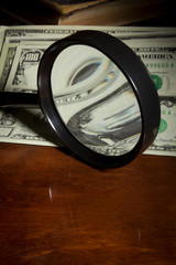 Magnifying glass and dollars