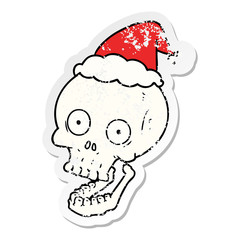 distressed sticker cartoon of a skull wearing santa hat