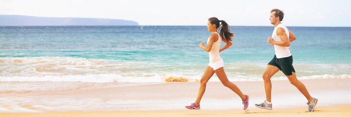 Run fit couple running together on beach banner panoramic background. Two fitness athlete jogging - summer active lifestyle.