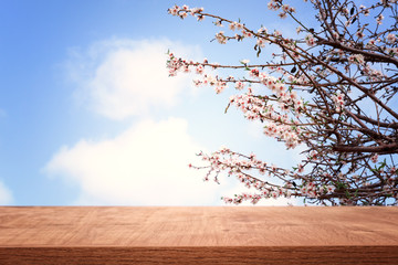 wooden table in front of spring blossom tree landscape. Product display and presentation