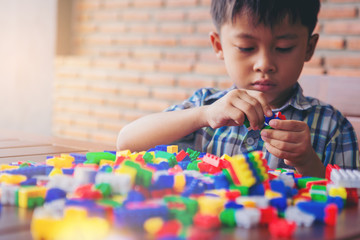 Little boy playing build construction with colorful plastic toy blocks. learning and education...