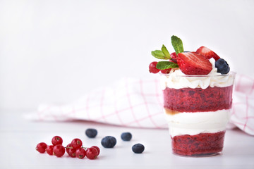 Cake dessert. Trifle red velvet in glass with fresh berry, mint leaves.