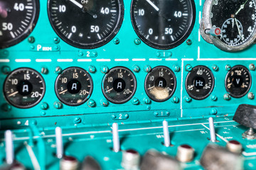 Dashboard of an old airplane. Many analog pointers, buttons and switches