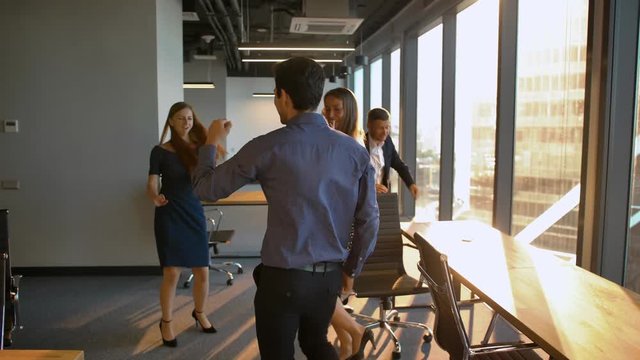 Group of Businesspeople dancing in office.