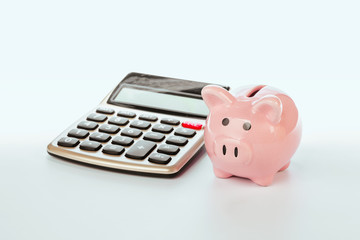 Piggy Bank with calculator on white background