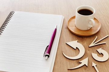 top view image of open notebook with blank pages next to cup of coffee on wooden table. ready for adding text or mockup