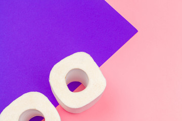 White toilet paper rolls on bright color block background