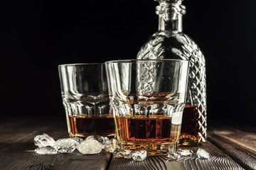 Whiskey glass and bottle on the old wooden table