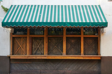 outdoor service windows in a pub with wood frames and a green awning