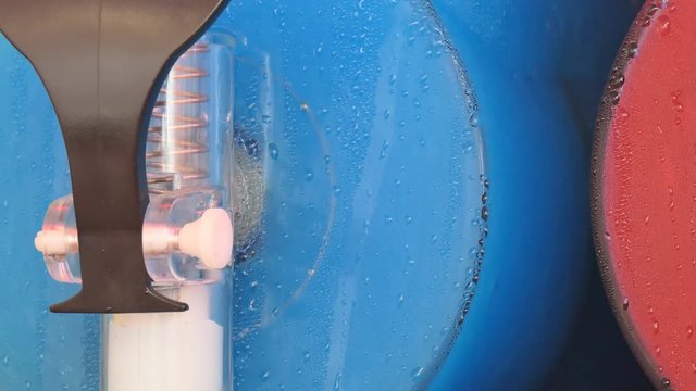 A close up view of blue slush being prepare in a slush machine.