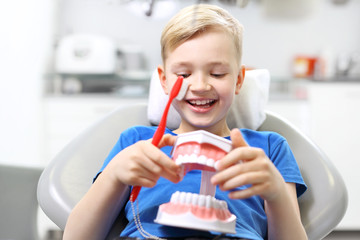 Stomatologia, radosne dziecko na fotelu dentystycznym
