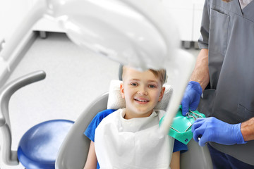 Dziecko u stomatologa. Dziecko na fotelu stomatologicznym podczas zabiegu leczenia zębów