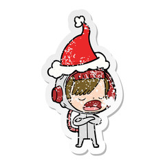 distressed sticker cartoon of a astronaut woman explaining wearing santa hat