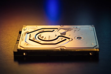 Hard disk on the table in dark colors and lighting close-up.