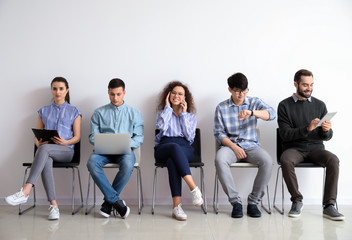 Young people waiting for job interview indoors - obrazy, fototapety, plakaty
