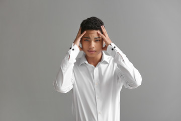 Sad African-American boy after failing school test on grey background