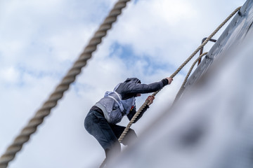 A man climbs an obstacle at a sporting event