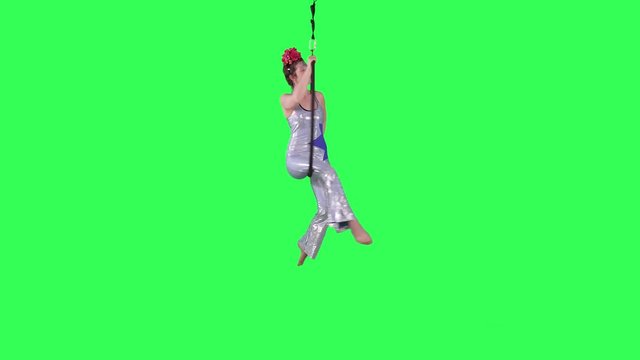 Beautiful Aerial Hoop Artist spins and performs wearing a circus suit over a green screen.