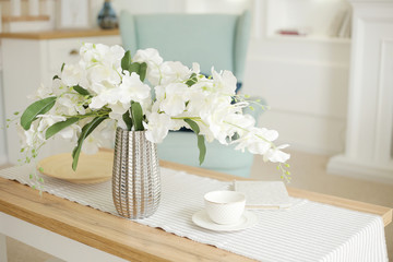 Light classic living room interior. coffee table and white orchid in vaz. A bright sunny day
