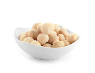 Bowl with peeled macadamia nuts on white background - obrazy, fototapety, plakaty