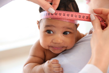 Pediatrician examining African-American baby in clinic
