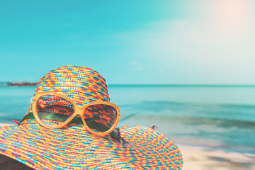 sunglasses and straw hat with blur sea and sky background