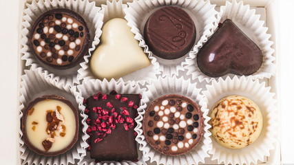 Assorted chocolates in a  box. Candies in a box. Top view. Closeup