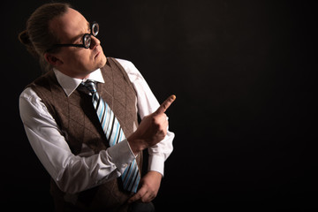 Funny nerd or geek pointing with finger to empty space