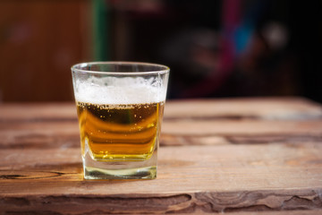 Glass with beer on a wooden background.