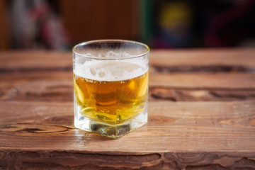 Glass with beer on a wooden background.