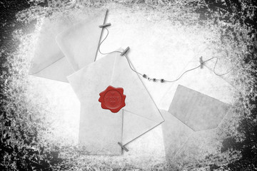 Post envelopes and vintage blank cards. Red wax seal with word love and heart shape. All objects are hanging on a rope attached with clothes clothespins. Objects are on white background