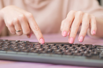 Woman typing on the keyboard. Housewife works at the computer.