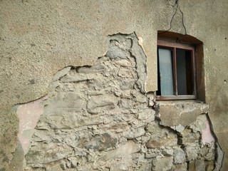 dilapidated wall of an old house with a window