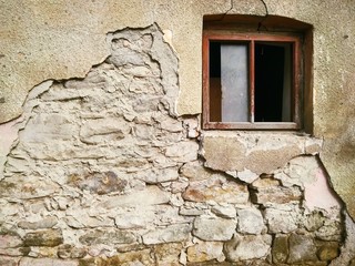 dilapidated wall of an old house with a window