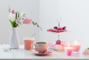 Fototapeta na wymiar Tulips in vase and cup of coffee with dessert on white backgrou