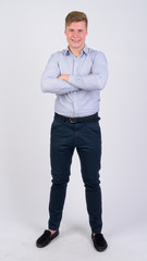 Fototapeta premium Full body shot of young happy blonde businessman smiling with arms crossed